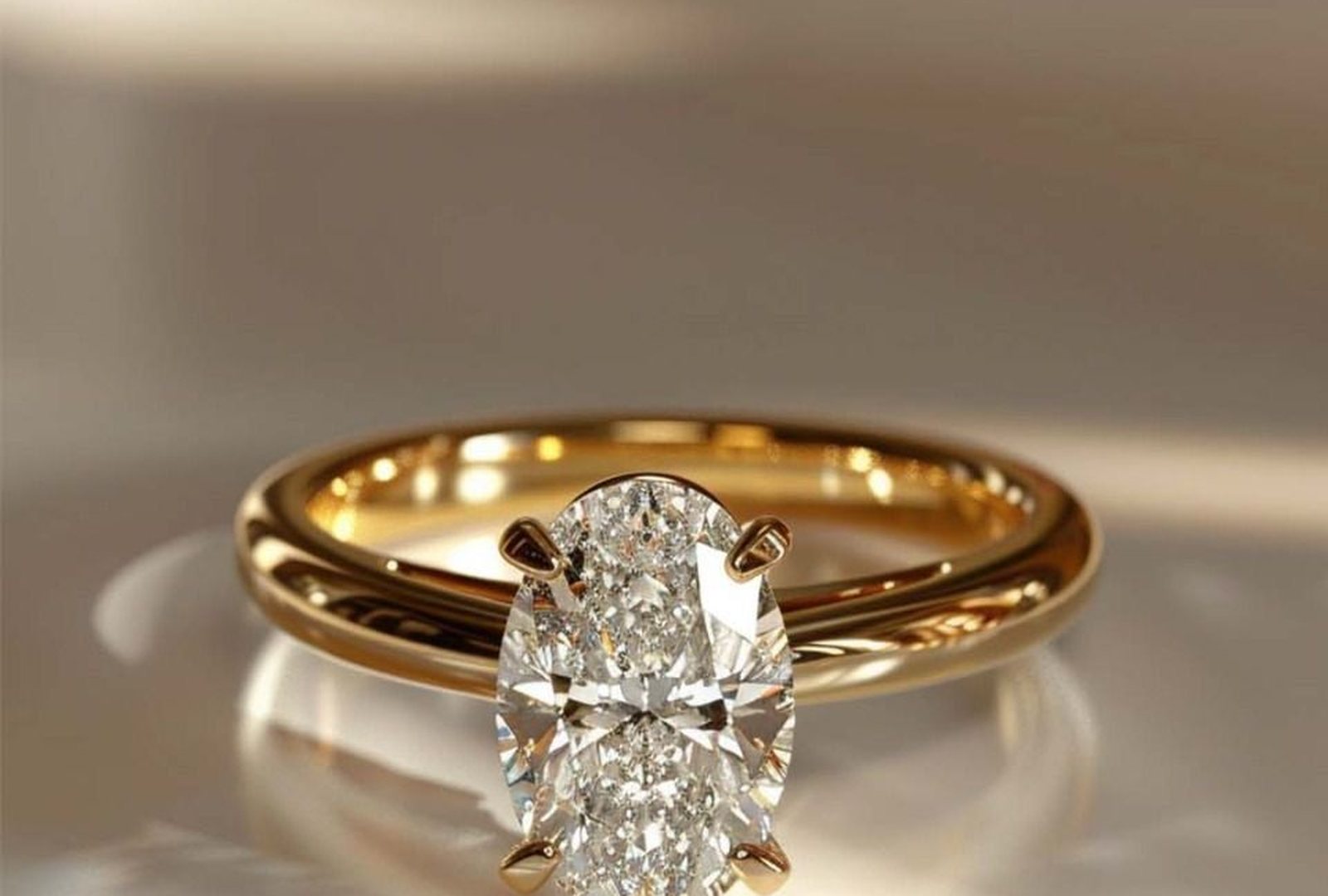An oval-cut diamond solitaire in yellow gold