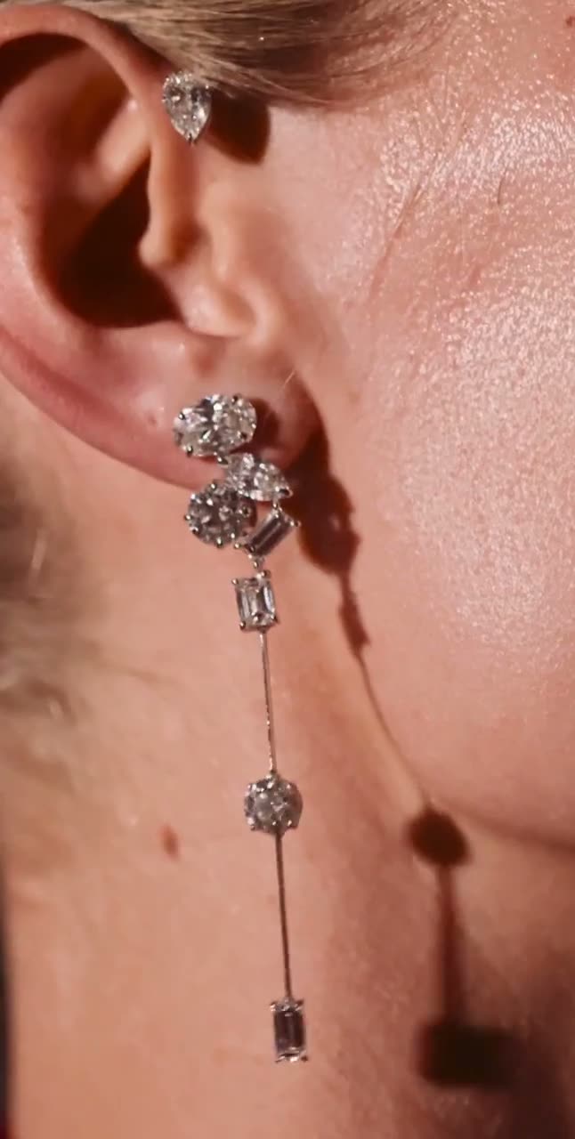 Diamond drop earrings and bracelets worn with a deep red dress