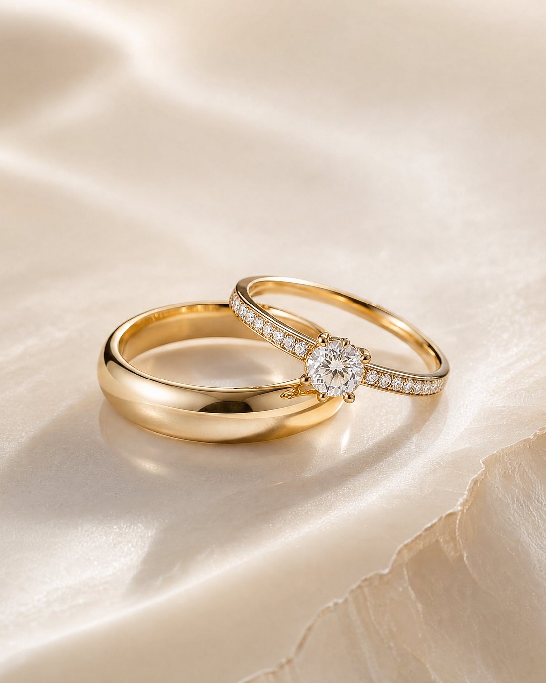 A plain gold band beside a diamond-set band, on silk